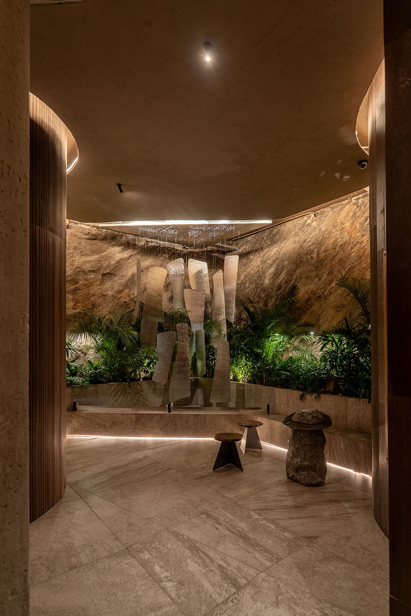 Casa FOA 2026, espacio en piedra con colgantes de vidrio y vegetación